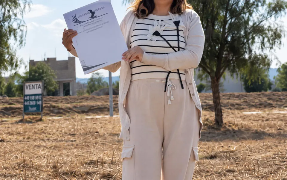 Documentación sostenida con ambas manos durante una operación inmobiliaria.